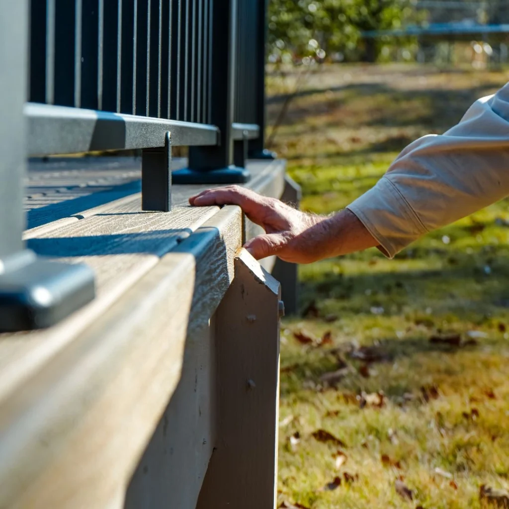 A builder inspecting a composite deck before handing issuing his deck and porch warranty.
