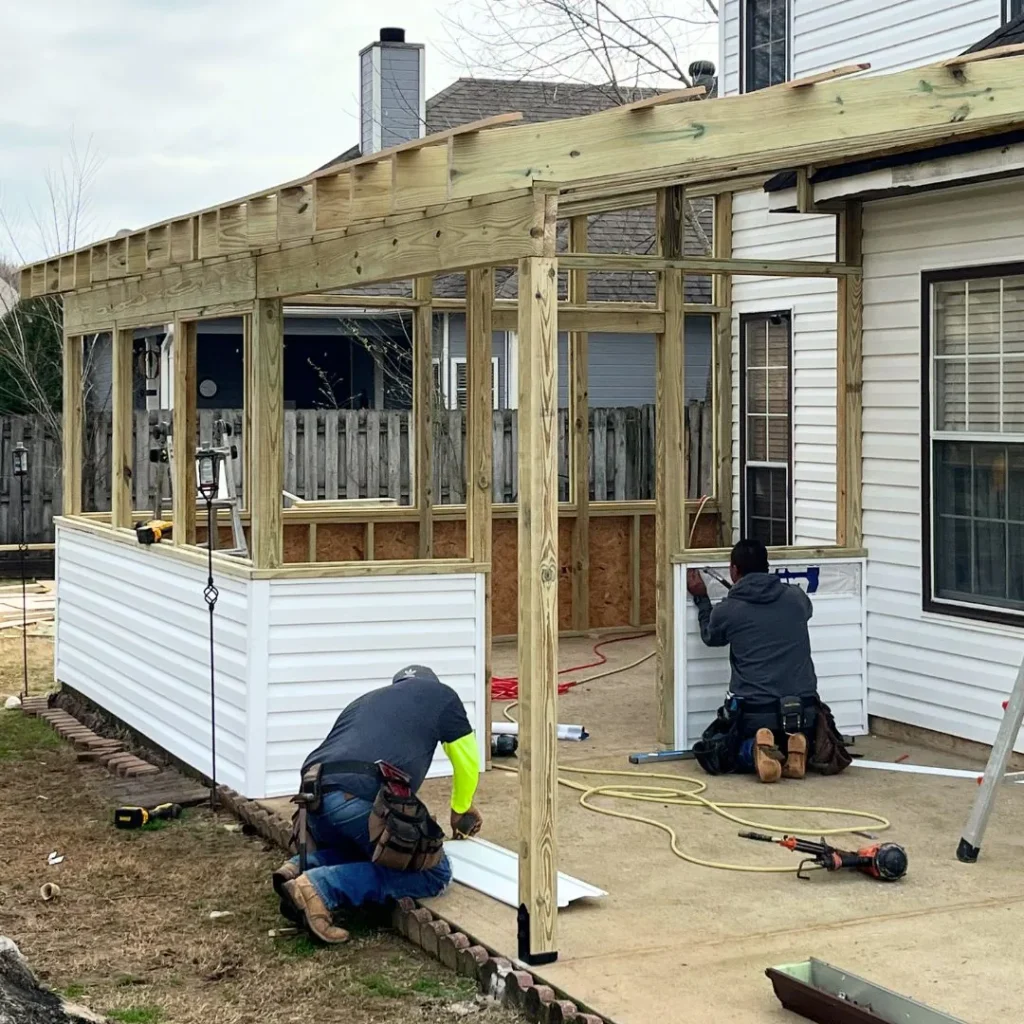 Men constructing a wooden patio enclosure