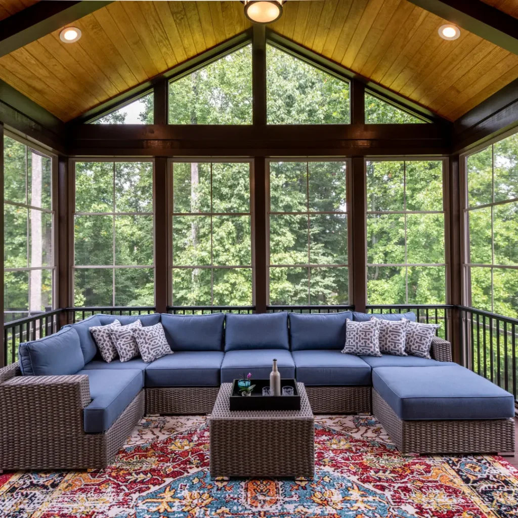 Screened porch with a rug and couch.